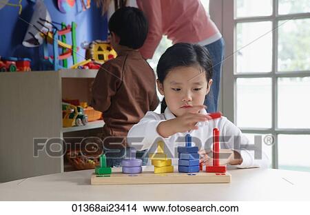 Young girl playing with stacking blocks View Large Photo Image Picture - Young girl playing with stacking blocks. Fotosearch