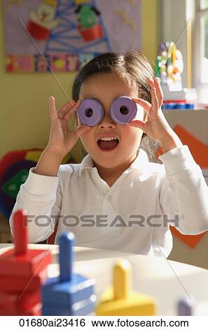 Young girl playing with stacking blocks, looking at camera View Large Photo Image Stock Photograph - Young girl playing with stacking blocks, looking at camera. Fotosearch