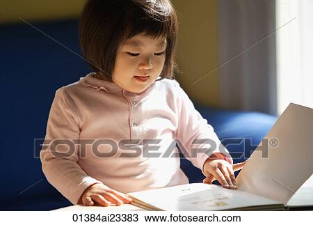 Stock Image - Young girl reading book. Fotosearch