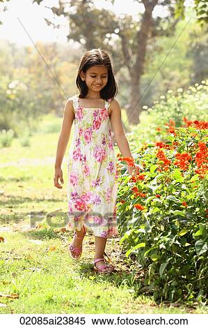 Young girl walking next to flowers View Large Photo Image Stock Photography - Young girl walking next to flowers. Fotosearch