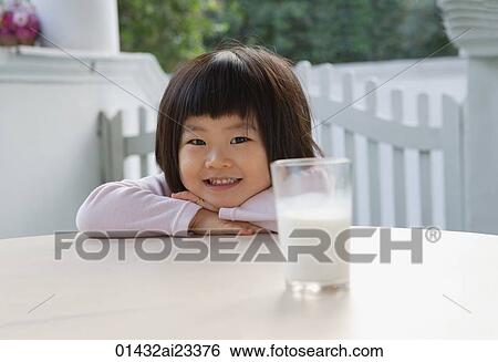 Young girl with glass of milk, looking at camera View Large Photo Image Stock Photograph - Young girl with glass of milk, looking at camera. Fotosearch