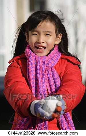 Stock Photo - Young girl with snowball looking at camera. Fotosearch