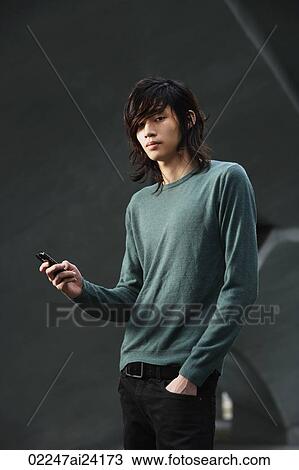 Stock Image - young man checking text messages. Fotosearch