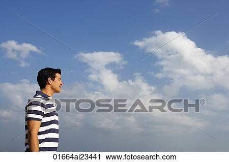 Stock Image - Young man looking at the sky. Fotosearch