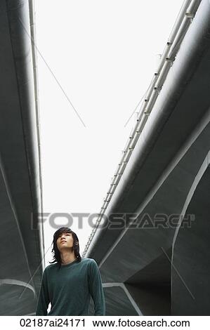 Stock Image - young man under freeway overpass. Fotosearch