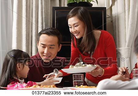 Young mother dishing up food View Large Photo Image Stock Photography - Young mother dishing up food. Fotosearch