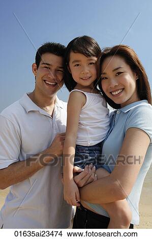 Young parents with daughter, looking at camera View Large Photo Image Picture - Young parents with daughter, looking at camera. Fotosearch