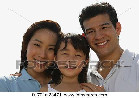 Stock Image - Young parents with daughter, looking at camera. Fotosearch
