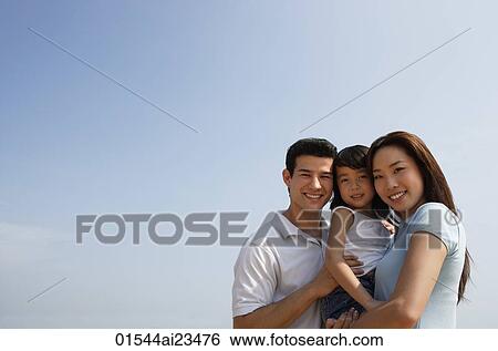 Young parents with daughter, looking at camera View Large Photo Image Stock Photograph - Young parents with daughter, looking at camera. Fotosearch