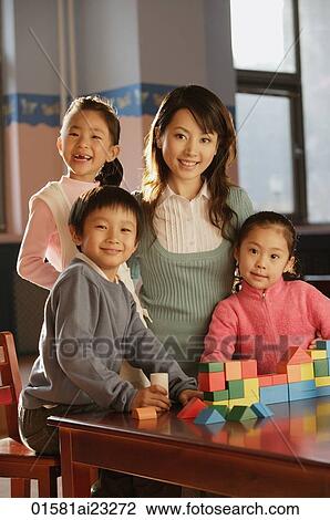 Stock Image - Young school children with their teacher. Fotosearch