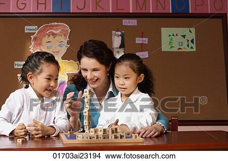Young school girls with their teacher in classroom View Large Photo Image Picture - Young school girls with their teacher in classroom. Fotosearch