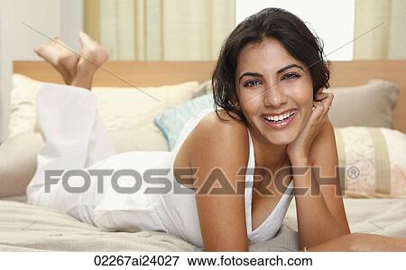 young woman leaning on arm, on bed View Large Photo Image Stock Photo - young woman leaning on arm, on bed. Fotosearch