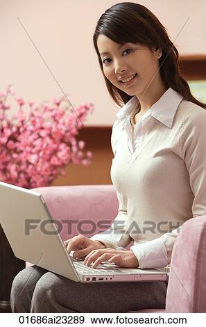 Stock Photo - Young woman using laptop. Fotosearch
