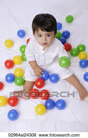 Stock Photo - baby boy playing with balls. Fotosearch