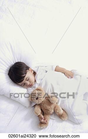 Stock Image - baby boy sleeping with teddy bear. Fotosearch