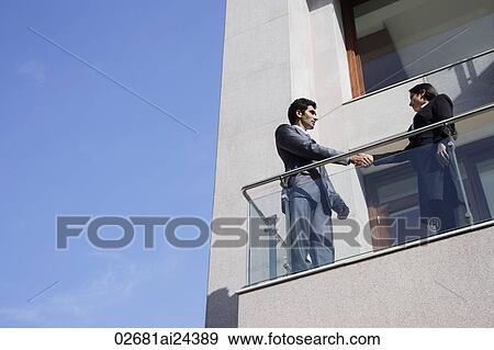 business associates at balcony shaking hands View Large Photo Image Stock Photo - business associates at balcony shaking hands. Fotosearch