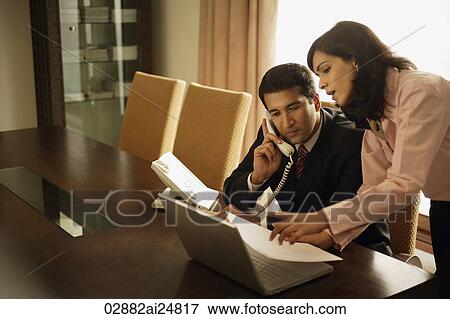Stock Photo - business associates having meeting. Fotosearch