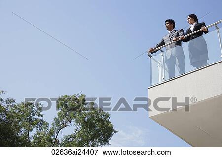 Stock Photo - business associates looking out from balcony. Fotosearch