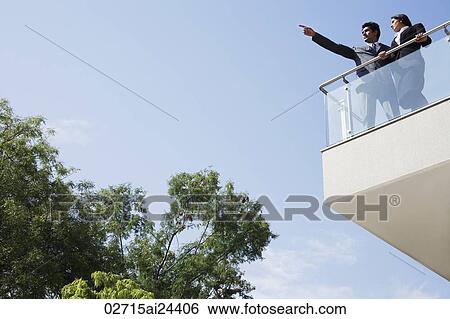 Stock Photograph - business associates looking out from balcony. Fotosearch