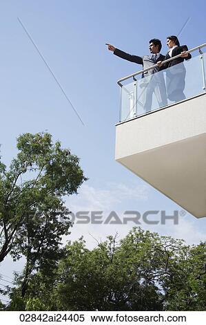 Stock Photography - business associates looking out from balcony. Fotosearch