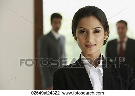 business woman smiling in foreground, two business men in background View Large Photo Image Stock Image - business woman smiling in foreground, two business men in background. Fotosearch