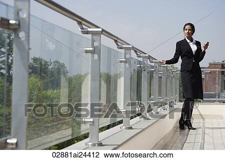 business woman with one hand on railing, with cell phone View Large Photo Image Stock Image - business woman with one hand on railing, with cell phone. Fotosearch