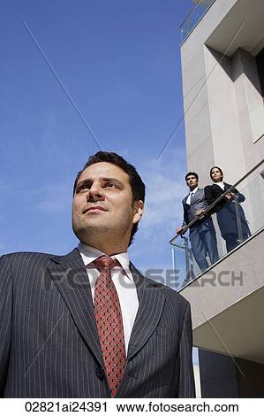 businessman in foreground, business associates looking down from balcony View Large Photo Image Stock Image - businessman in foreground, business associates looking down from balcony. Fotosearch