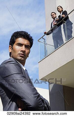 businessman in foreground, business associates on balcony View Large Photo Image Stock Image - businessman in foreground, business associates on balcony. Fotosearch