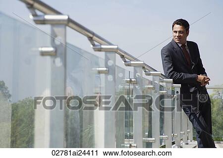 businessman leaning against railing on balcony View Large Photo Image Stock Image - businessman leaning against railing on balcony. Fotosearch