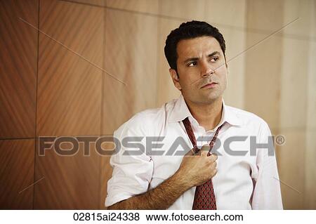 Stock Photo - businessman loosening tie. Fotosearch