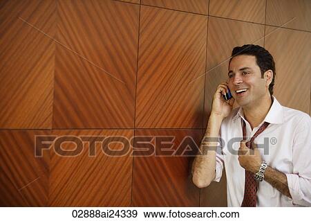 businessman on cell phone, loosening tie View Large Photo Image Stock Photo - businessman on cell phone, loosening tie. Fotosearch