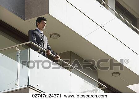 businessman standing at balcony View Large Photo Image Stock Image - businessman standing at balcony. Fotosearch