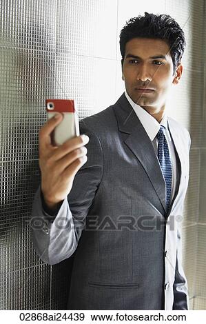 Stock Photo - businessman taking photo of himself using mobile phone. Fotosearch