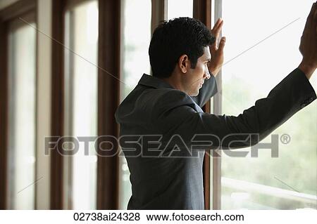 Stock Photo - businessman with hands on window. Fotosearch