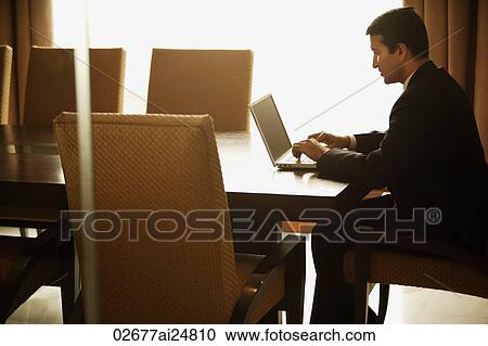 Stock Image - businessman working on laptop computer in meeting room. Fotosearch