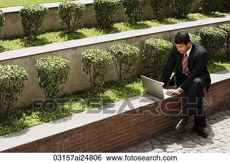 Stock Photograph - businessman working outside, laptop computer. Fotosearch