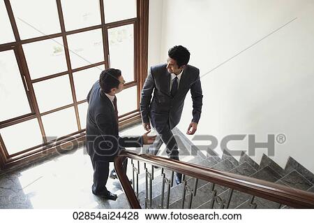 businessmen chatting while walking up the stairs View Large Photo Image Stock Photo - businessmen chatting while walking up the stairs. Fotosearch