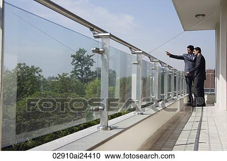 Stock Image - businessmen standing at balcony. Fotosearch