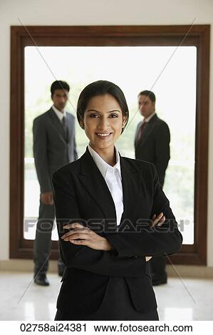 businesswoman posing with two businessmen in background View Large Photo Image Stock Image - businesswoman posing with two businessmen in background. Fotosearch