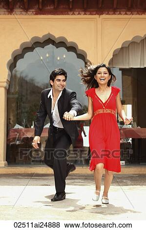 Stock Photo - couple laughing, holding hands. Fotosearch