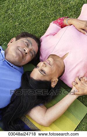 Stock Photo - couple lying on the grass. Fotosearch