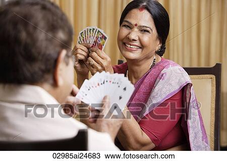 Stock Image - couple playing cards, woman wearing sari and bindi. Fotosearch