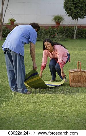 Stock Photo - couple setting up picnic. Fotosearch