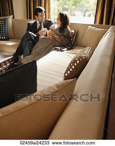 Stock Image - couple sitting on couch. Fotosearch
