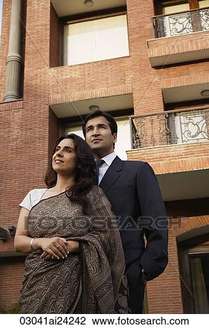 Stock Image - couple standing in front of home. Fotosearch