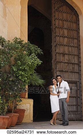 Stock Image - couple standing in giant doorway. Fotosearch