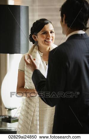 Stock Image - man and woman talking in hotel lobby. Fotosearch