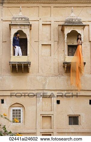 Stock Image - man and women on balconies, woman in sari. Fotosearch