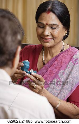 man giving woman jewelry, woman wearing sari and bindi View Large Photo Image Stock Photography - man giving woman jewelry, woman wearing sari and bindi. Fotosearch