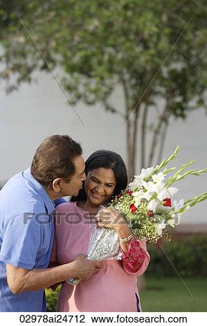 Stock Image - man kissing woman on cheek. Fotosearch